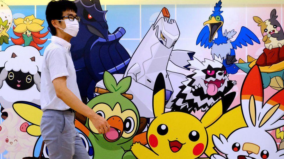 Мужчина проходит мимо граффити в магазине покемонов в Токио