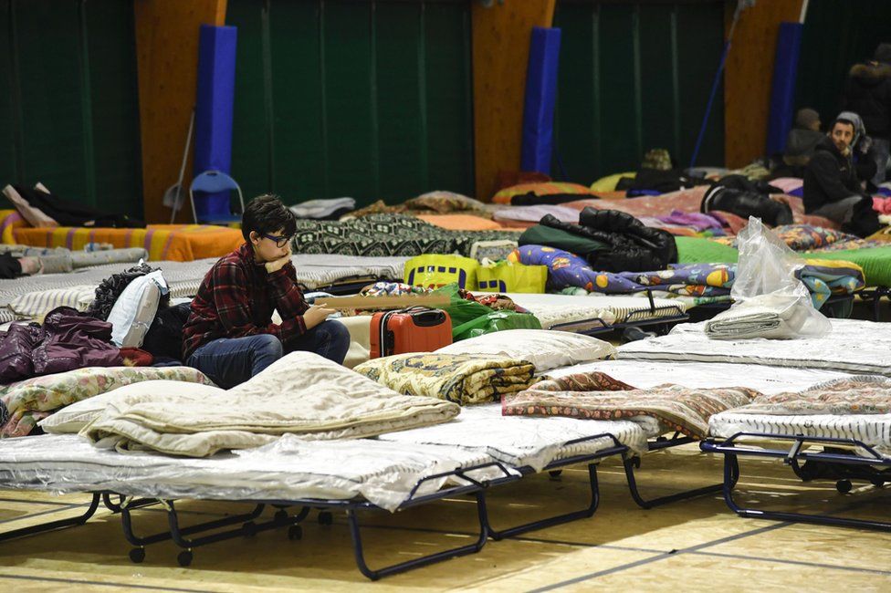 A teenager sits on a bed in a large tent erected in Montereale, Abruzzo, 18 January