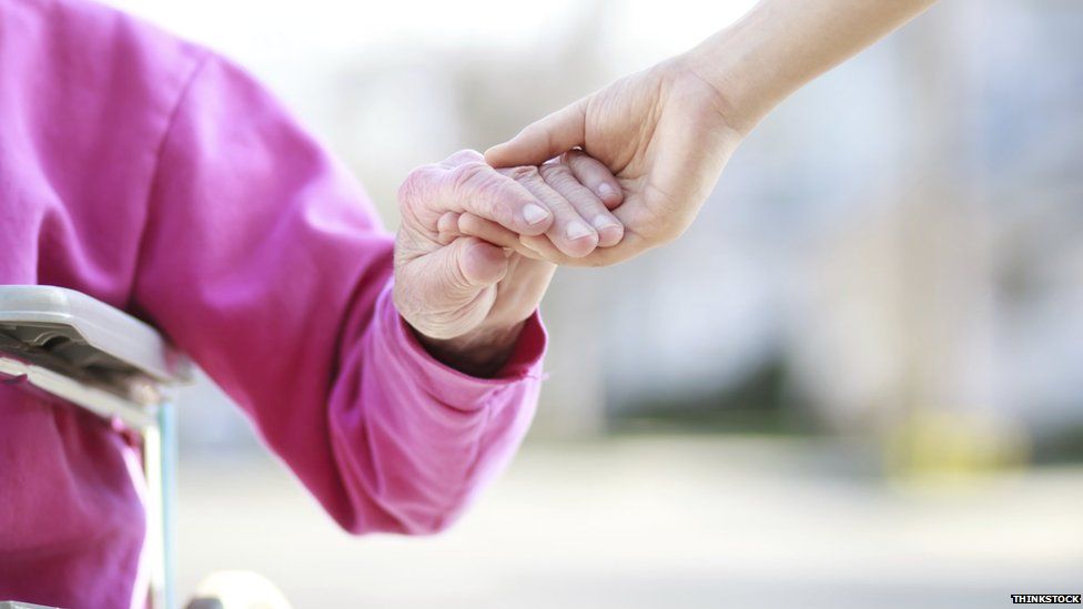 Elderly person's hand being held