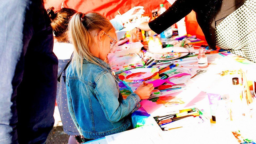 Child colouring in at a mini pride event