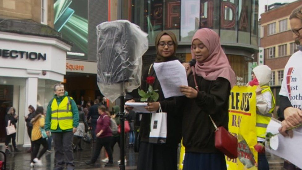 A Muslim woman speaks to the crowd outlining her experiences of abuse on public transport