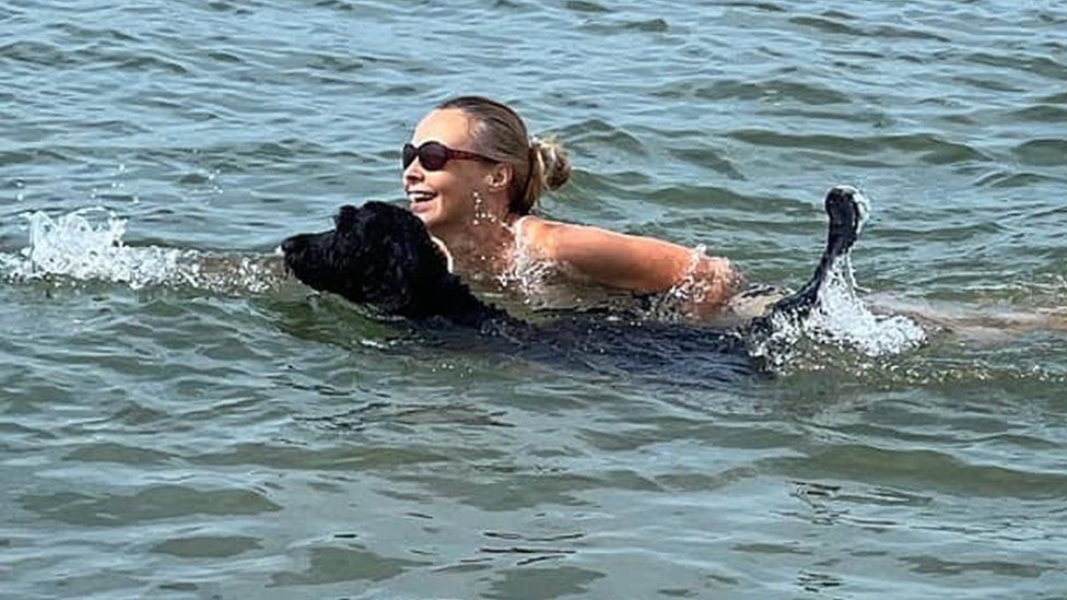 Woman and a dog swimming in the sea