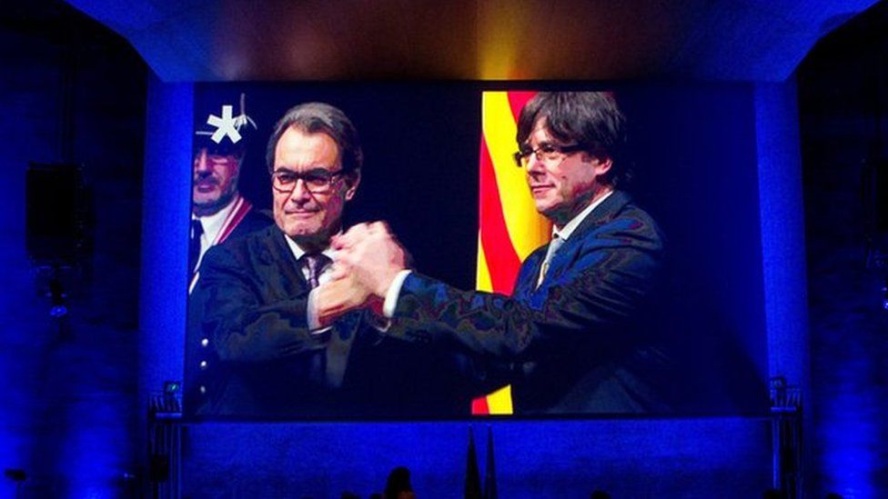 Catalonia's leader, Carles Puigdemont (R), on a big screen. projected into a Barcelona event, 13 January 2018