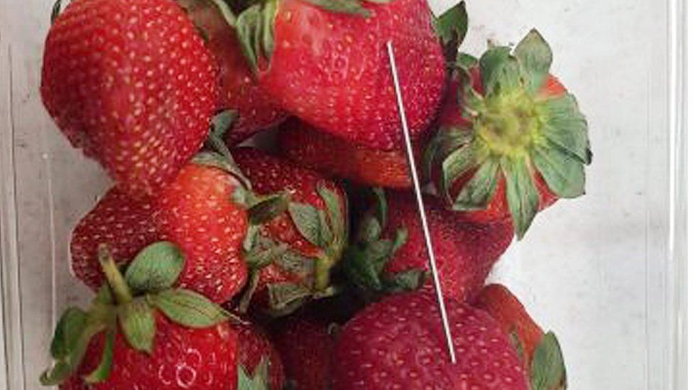 A photo from Queensland police shows a thin piece of metal seen among a punnet of strawberries