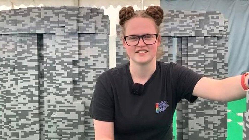Emily Corl, Lego Brick Artist sits in front of the 1.6 metre sculpture