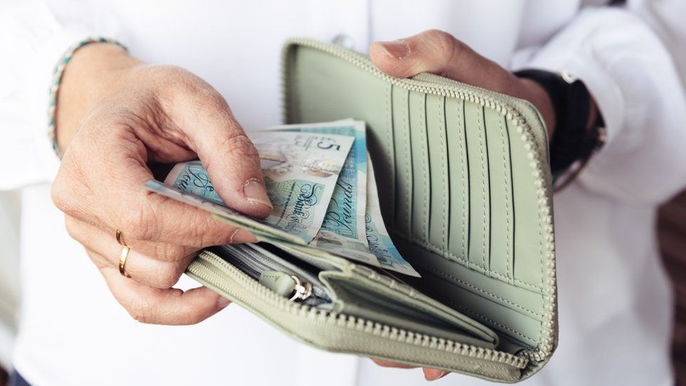 Woman looking astatine  wealth  successful  purse