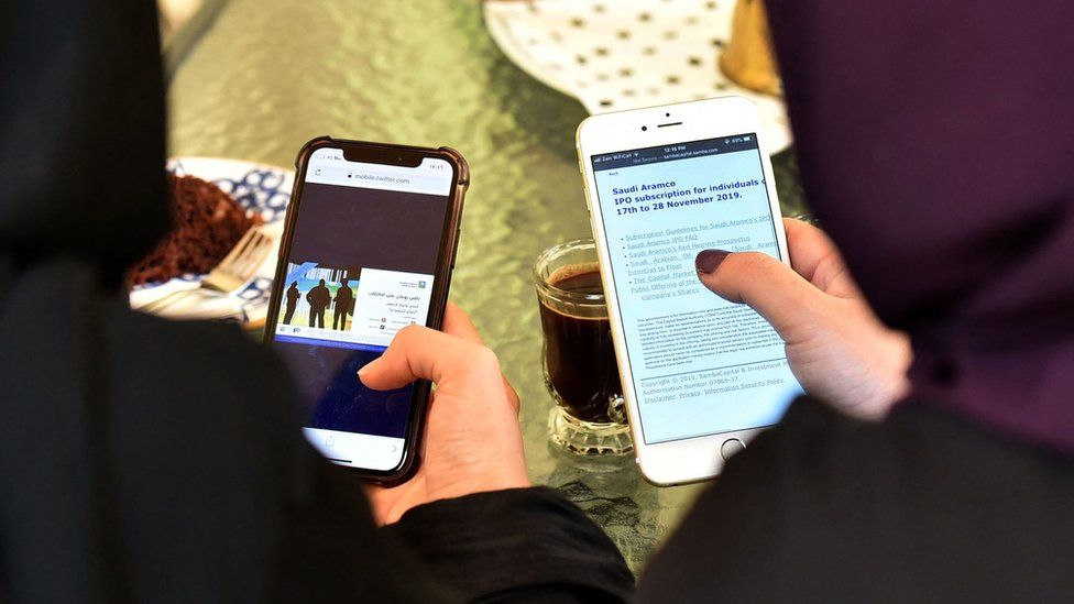 File photo shows women looking at the internet on their mobile phones in Saudi Arabia (27 November 2019)