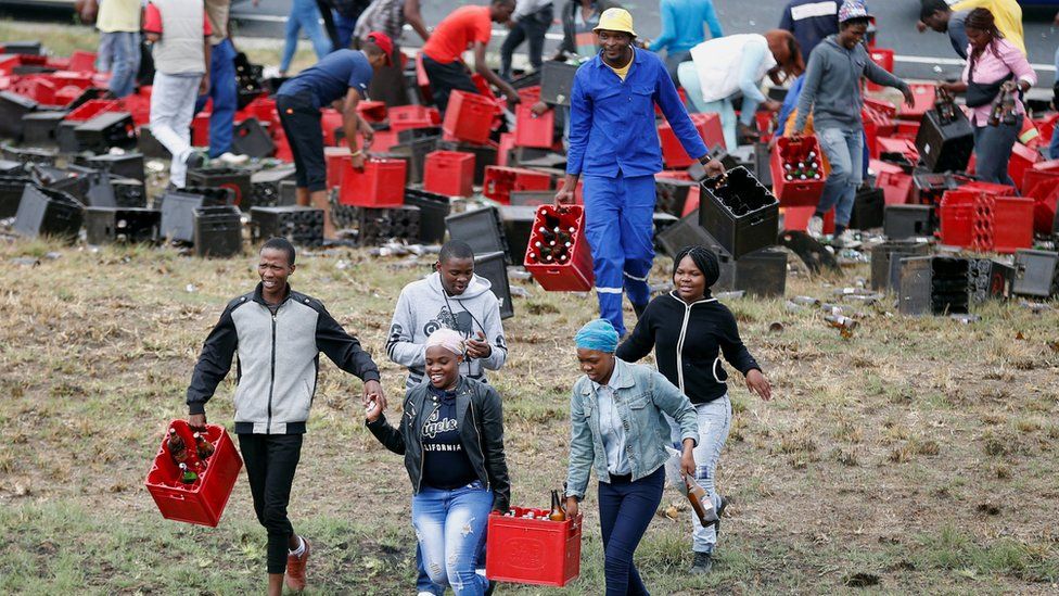 People carrying crates of beer away from a truck, near Johannesburg, South Africa - Friday 29 September 2017