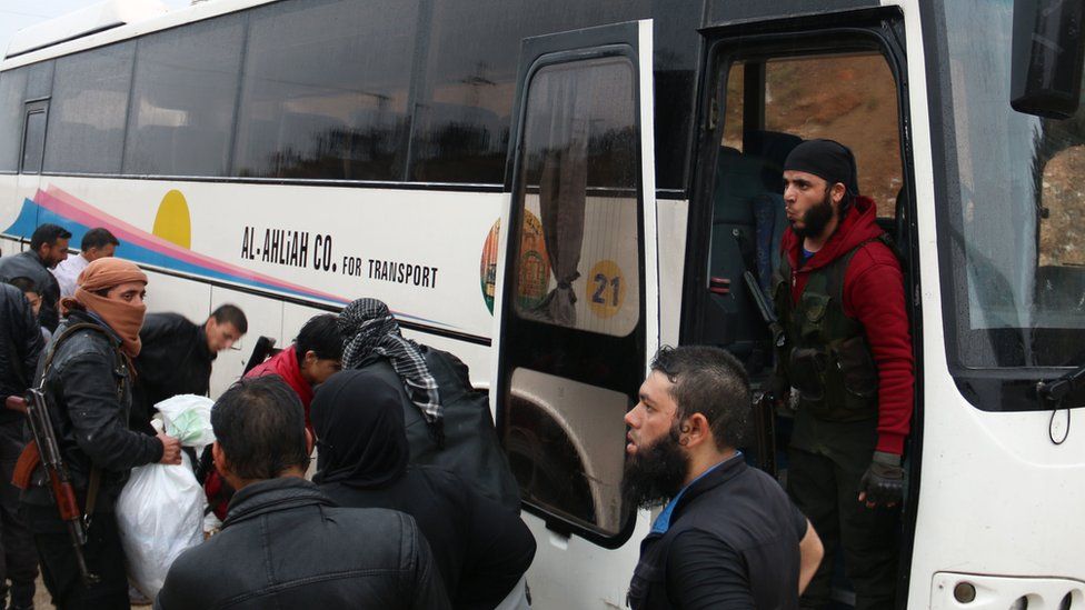 Rebels board a bus in Rastan, Syria, 7 May
