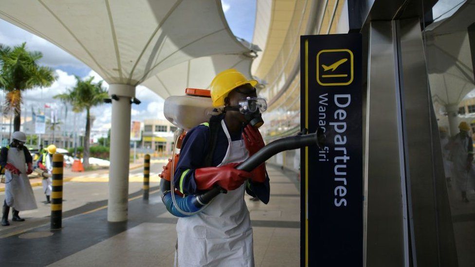 A man spraying disinfectant in an sirport