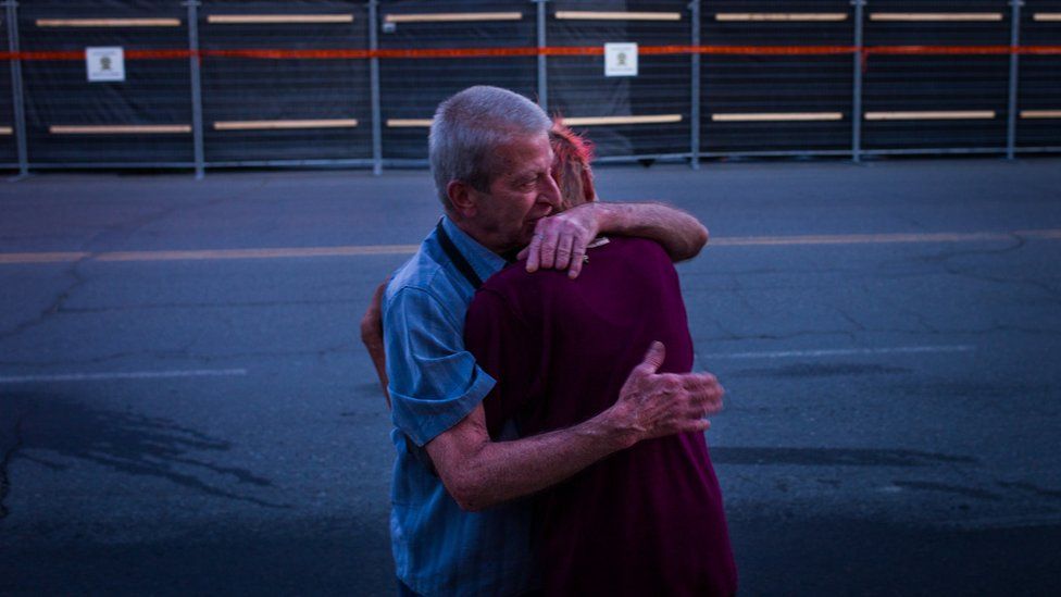 Marcel Larrivee (L) comforts Patricia Landry after the pair first witnessed the aftermath of the destruction
