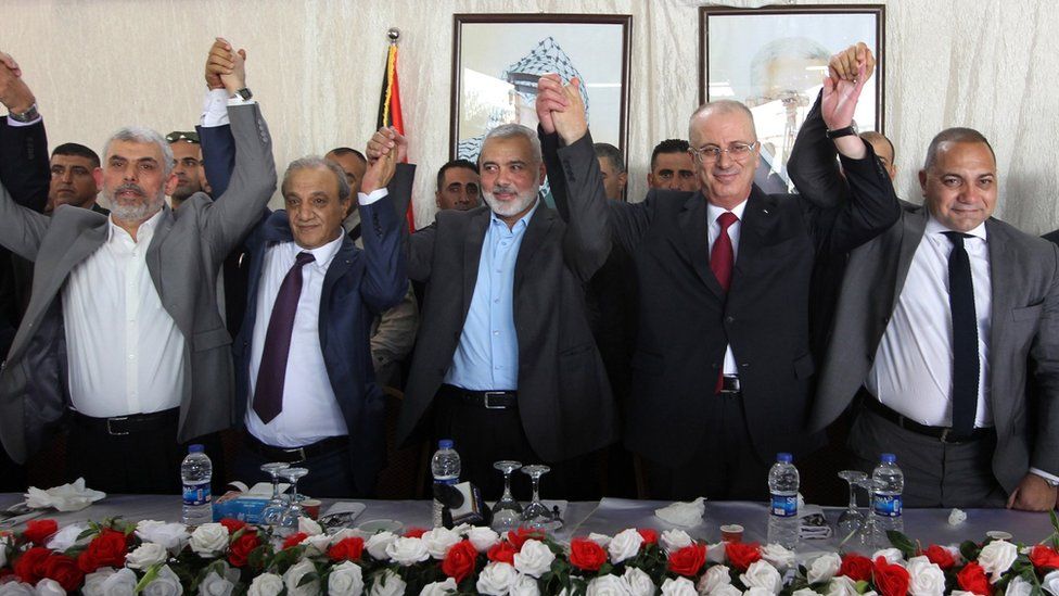 From L to R: Hamas Gaza chief Yahya Sinwar, Director of Palestinian General Intelligence in the West Bank Majid Faraj, Hamas political leader Ismail Haniya, Palestinian Prime Minister Rami Hamdallah and an Egyptian mediator hold hands during a meeting in Gaza City (2 October 2017)