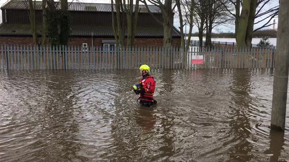 A firefighter in flood water
