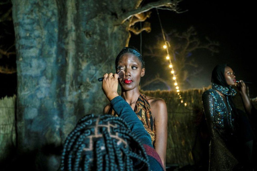 A model has the final touches done to her make up before heading to the catwalk during the 19th Dakar Fashion Week held at the Baobab forest in Nguekhokh, some 70kms south of Dakar, on December 18, 2021