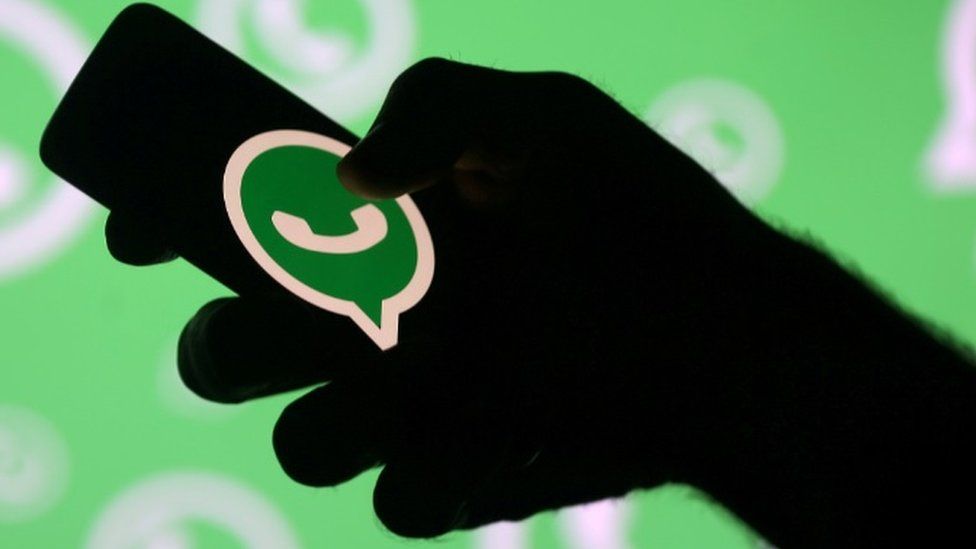 Hand holding smartphone with Whatsapp logo