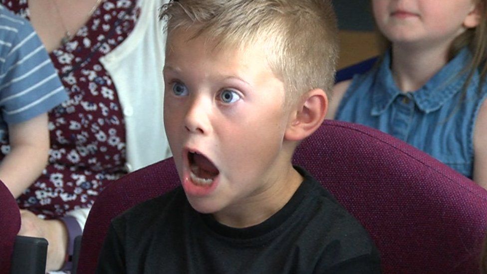 A child reacts to seeing Moe the monkey on screen
