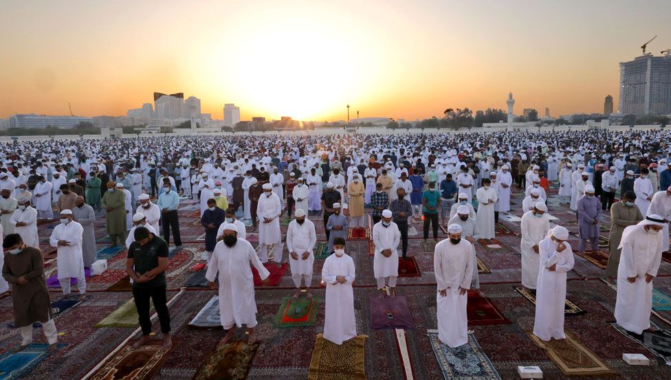 Worshippers perform the Eid al-Fitr morning prayer with a sunrise behind them at Dubai's Eid Musalla in the Gulf emirate's old port area