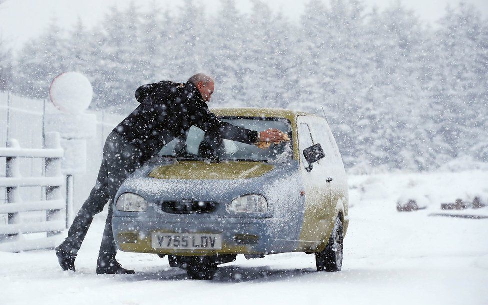 The owner of a three-wheeled Reliant Robin car battles snow