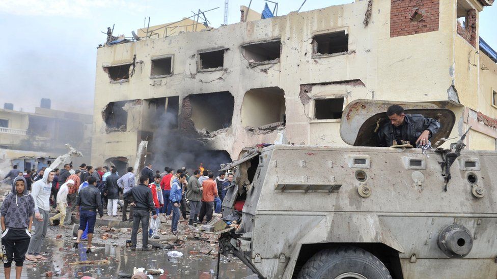 The aftermath of a car bomb attack outside a police station in North Sinai's provincial capital of El-Arish