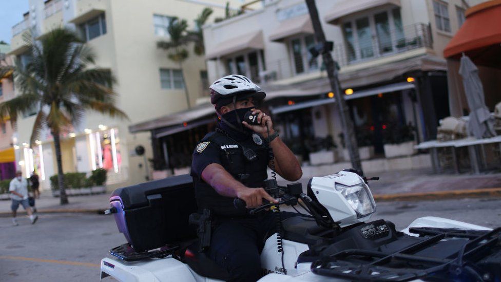 A Miami police officer wears a mask to enforce the city's mask mandate