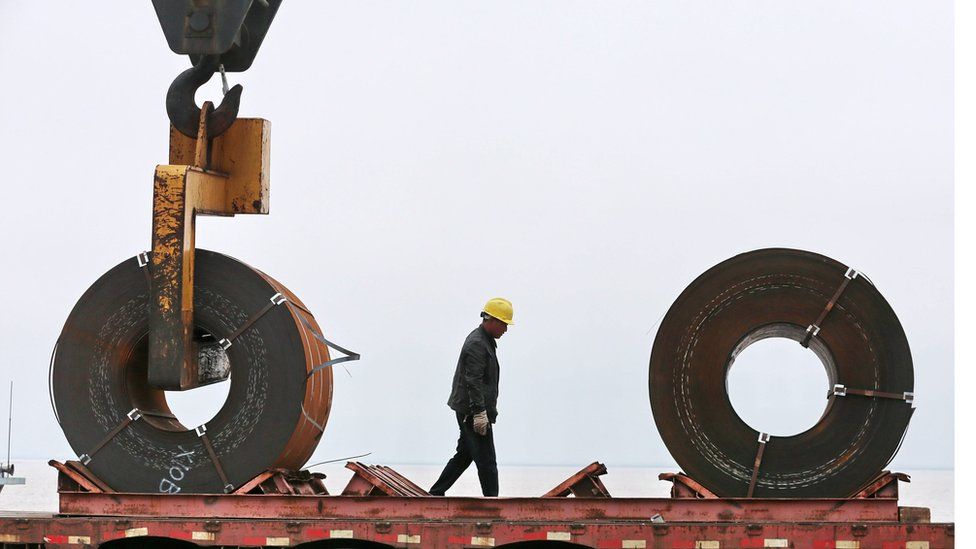 This photo taken on May 19, 2018 shows a worker preparing to lift a roll of steel with a crane at a shipyard in Nantong in China's eastern Jiangsu province.