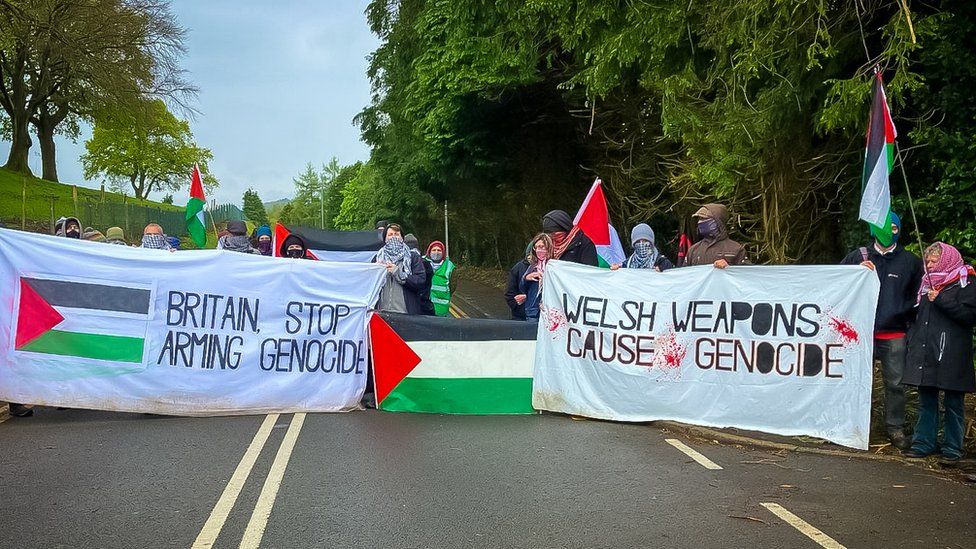 Protesters waving Palestinian flags and holding a banners saying Welsh weapons cause genocide