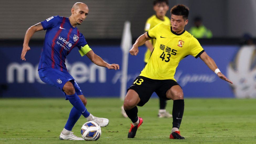 Начо Инса из Джохор Дарул Тазим контролирует мяч под давлением Чена Чжэнфэна из Гуанчжоу во время матча группы I Лиги чемпионов AFC 15 апреля 2022 года.