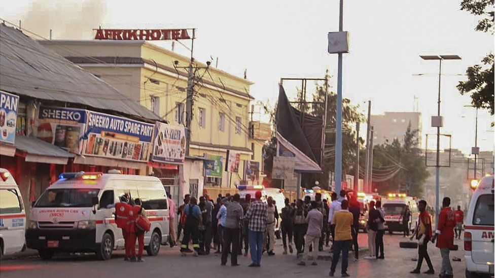 Общий вид на место взрыва бомбы в отеле Afrik в Могадишо, Сомали, с толпой на улице
