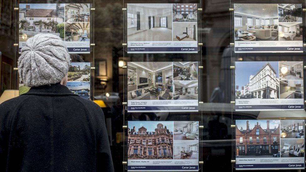 Houses for sale in the window of an estate agents in London