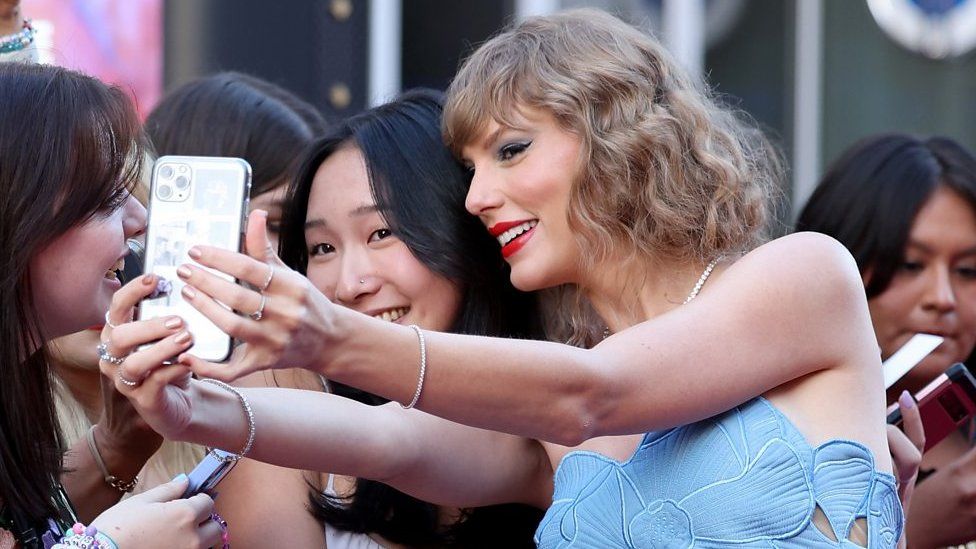 Taylor Swift taking selfie with fan