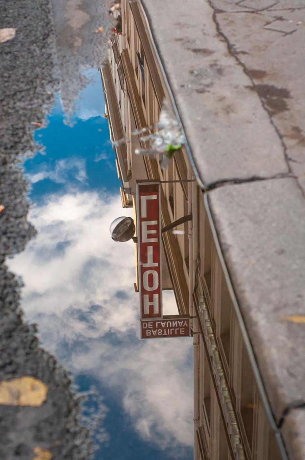Hotel sign reflected in a puddle