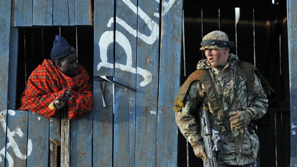 Солдат и кенийец, нанятый для игры в «повстанца», принимают участие в симуляторе военных учений Учебного подразделения британской армии в Кении (BATUK) вместе с Силами обороны Кении (KDF) на ранчо ол-Дайга, высоко в Кении. Плато Лайкипия 27 марта 2018 г.
