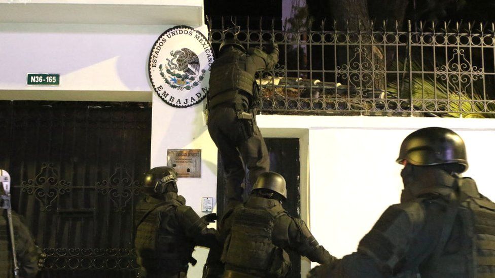 Ecuadorian police special forces are pictured outside the Mexican embassy in Quinto, Ecuador, with one member of the group scaling the wall of the embassy