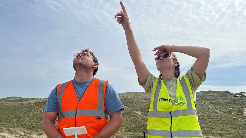 Drone operators in flourescent clothing