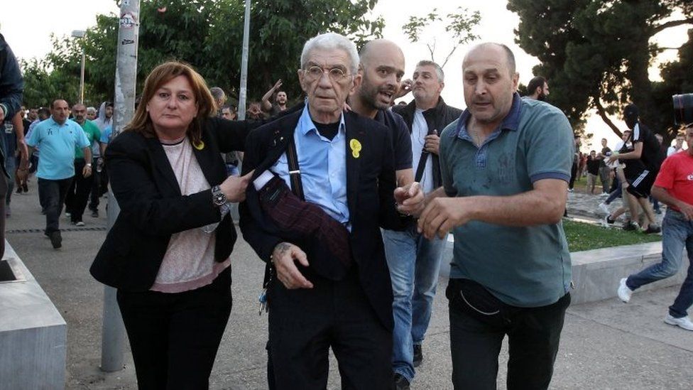 Mayor of Thessaloniki, Yiannis Boutaris (C), is aided after being attacked by a group of nationalists during Remembrance Day on 19 May 2018.