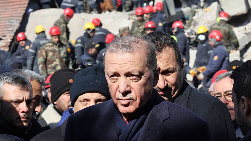 Turkish President Recep Tayyip Erdogan tours the site of destroyed buildings during his visit to the city of Kahramanmaras in southeast Turkey