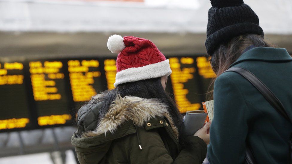 A traveller wears a festive themed hat in the departure hall of Paddington railway station, in London, U.K