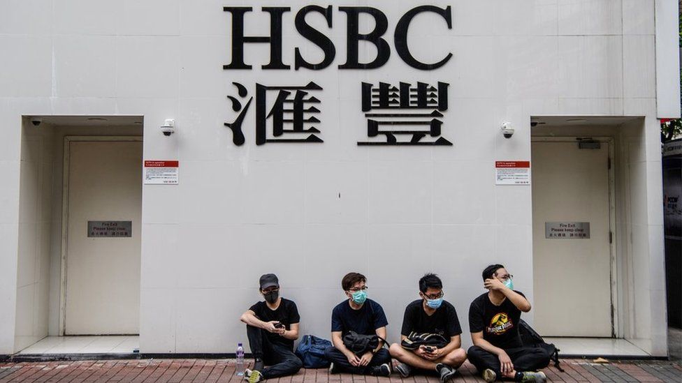Protesters sit outside a HSBC in the Kowloon district of Hong Kong on August 11, 2019, in the latest opposition to a planned extradition law that was quickly evolved into a wider movement for democratic reforms