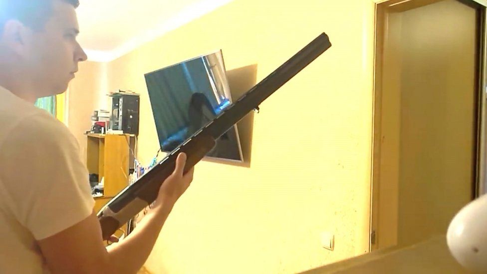 This image taken from a heavily edited Belarusian state video shows Andrey Zeltser apparently holding a gun