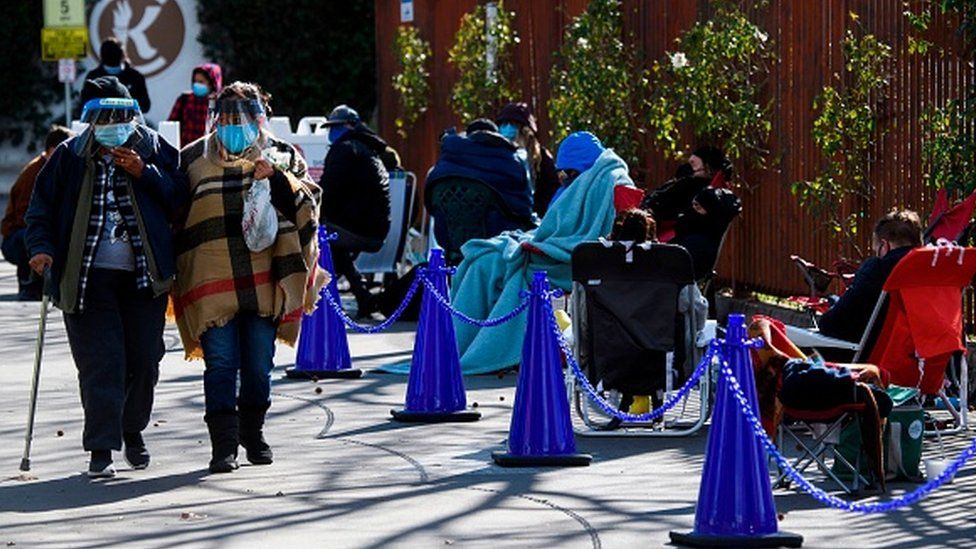 Люди без предварительной записи в очереди, ожидающие потенциального шанса на вакцинацию против Covid-19 в Лос-Анджелесе, Калифорния