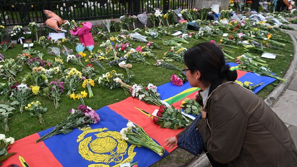 People place flowers with condolence messages outside Windsor Castle