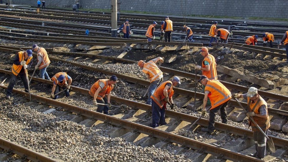 Workers fix damaged railway tracks following a night rocket attack in Kharkiv,