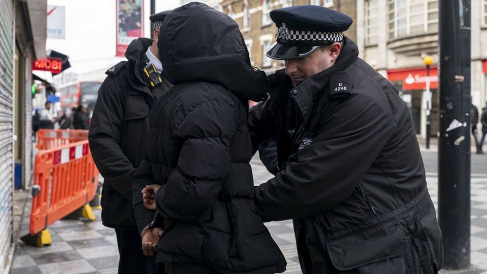 A person is detained by Metropolitan Police officers in Croydon, south London