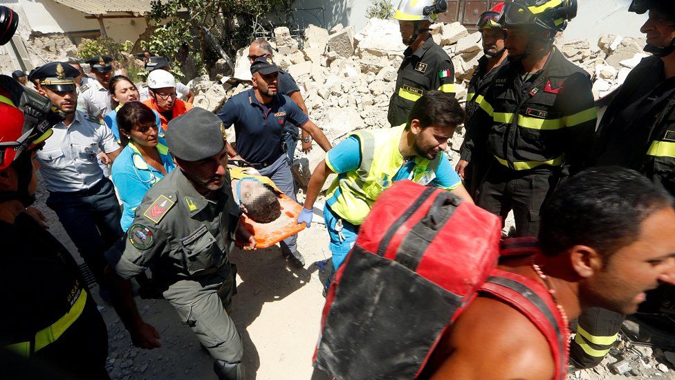 Rescue workers carry a child after an earthquake hits the island of Ischia, in Naples, Italy August 22, 2017