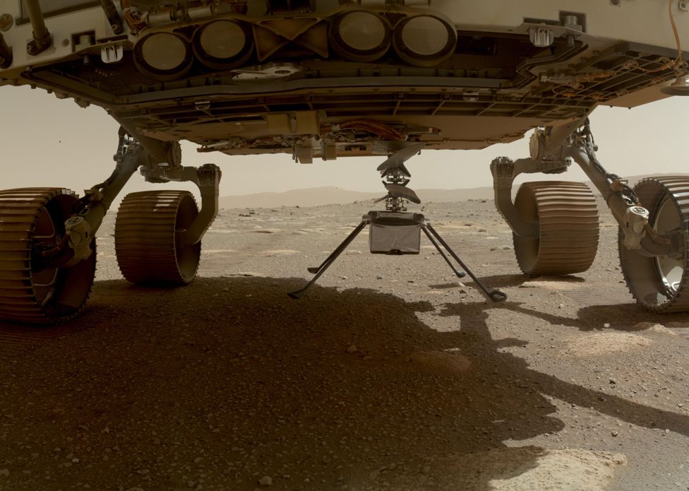 Nasa's Ingenuity helicopter can be seen with all four of its legs deployed below the Perseverance rover, on 30 March 2021