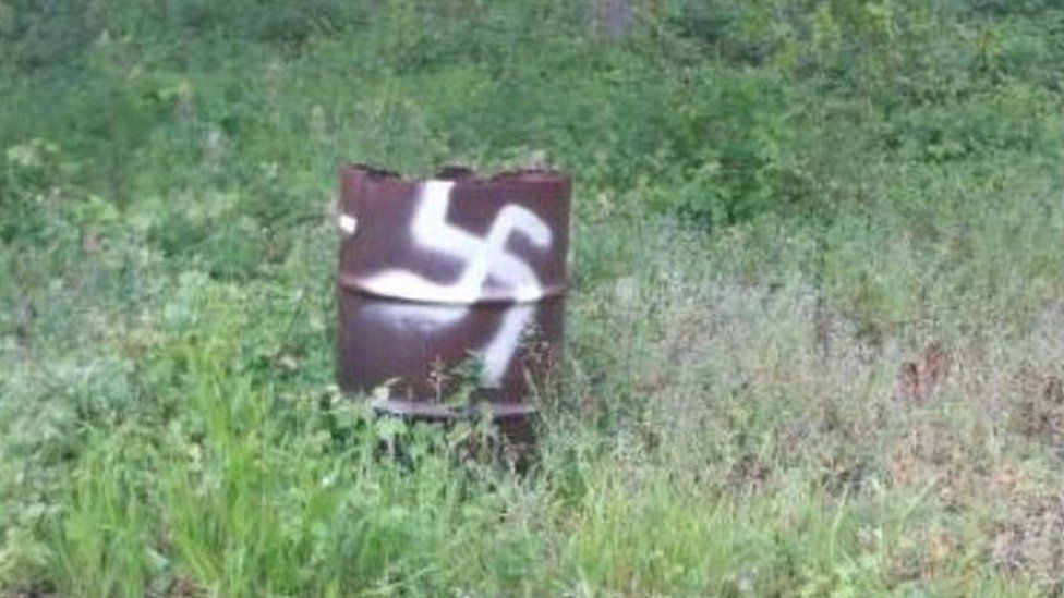 Swastika on disused fuel drum at the site