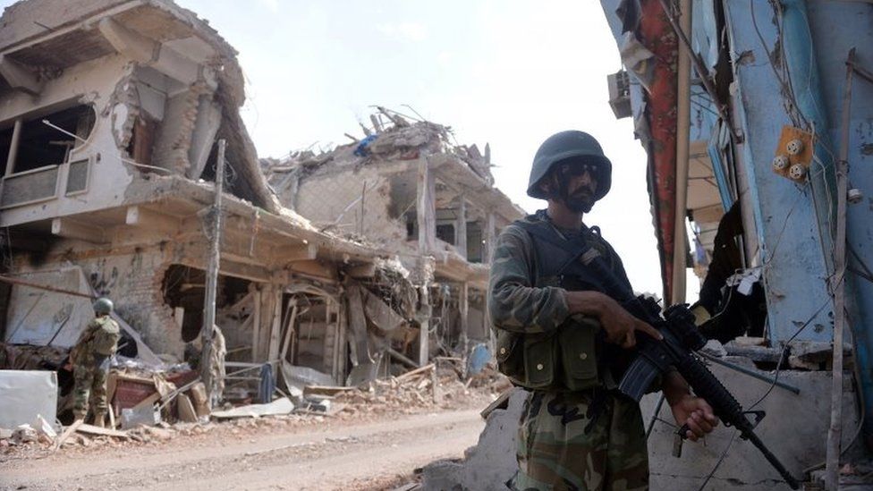 Pakistani soldiers stand guard at a destroyed empty bazaar during a military operation against Taliban militants in the main town of Miranshah in North Waziristan on July 9, 2014.