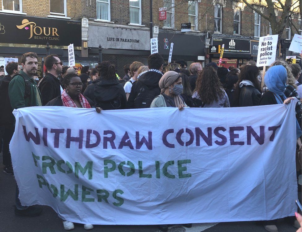 Protesters hold a 'withdraw consent from police powers' sign