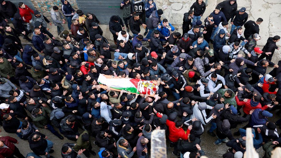 Люди несут тело Алаа Шихама, который, по словам палестинских официальных лиц, был убит израильскими войсками в лагере беженцев Каландия на оккупированном Западном берегу (15 марта 2022 г.)