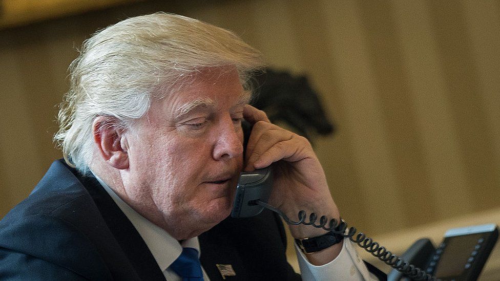 President Donald Trump speaks on the phone with Russian President Vladimir Putin in the Oval Office of the White House.
